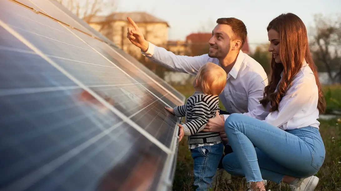 Familie plant nachhaltiges Wohnen mit Solarenergie Familie betrachtet Solarmodule als Symbol für nachhaltiges und energieeffizientes Wohnen.