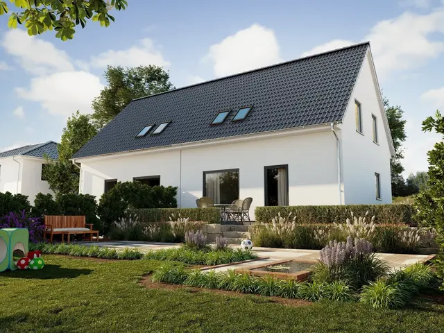 Modernes Einfamilienhaus mit Satteldach, Terrasse und naturnah gestaltetem Garten.