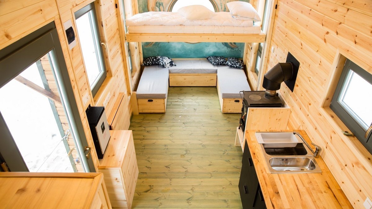 Kleiner Wohnraum mit integrierter Küche, Schlafbereich und clever genutztem Stauraum aus Holz