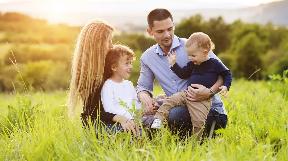 Familie mit zwei Kindern genießt gemeinsame Zeit auf einer Wiese