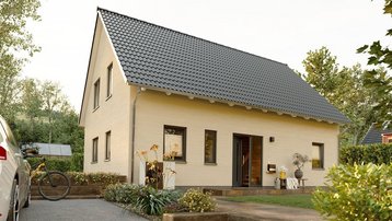 Modernes Massivhaus mit Satteldach, gepflasterter Zufahrt und Garten
