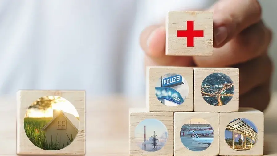 Infrastruktur und Versorgung am Wohnort Holzwürfel mit Symbolen für Haus, Gesundheit, Sicherheit und Infrastruktur