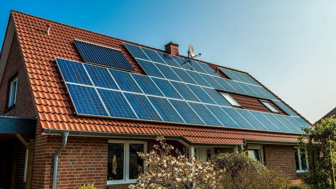Einfamilienhaus mit Photovoltaikanlage Klinkerhaus mit rotem Satteldach und großflächiger Photovoltaikanlage